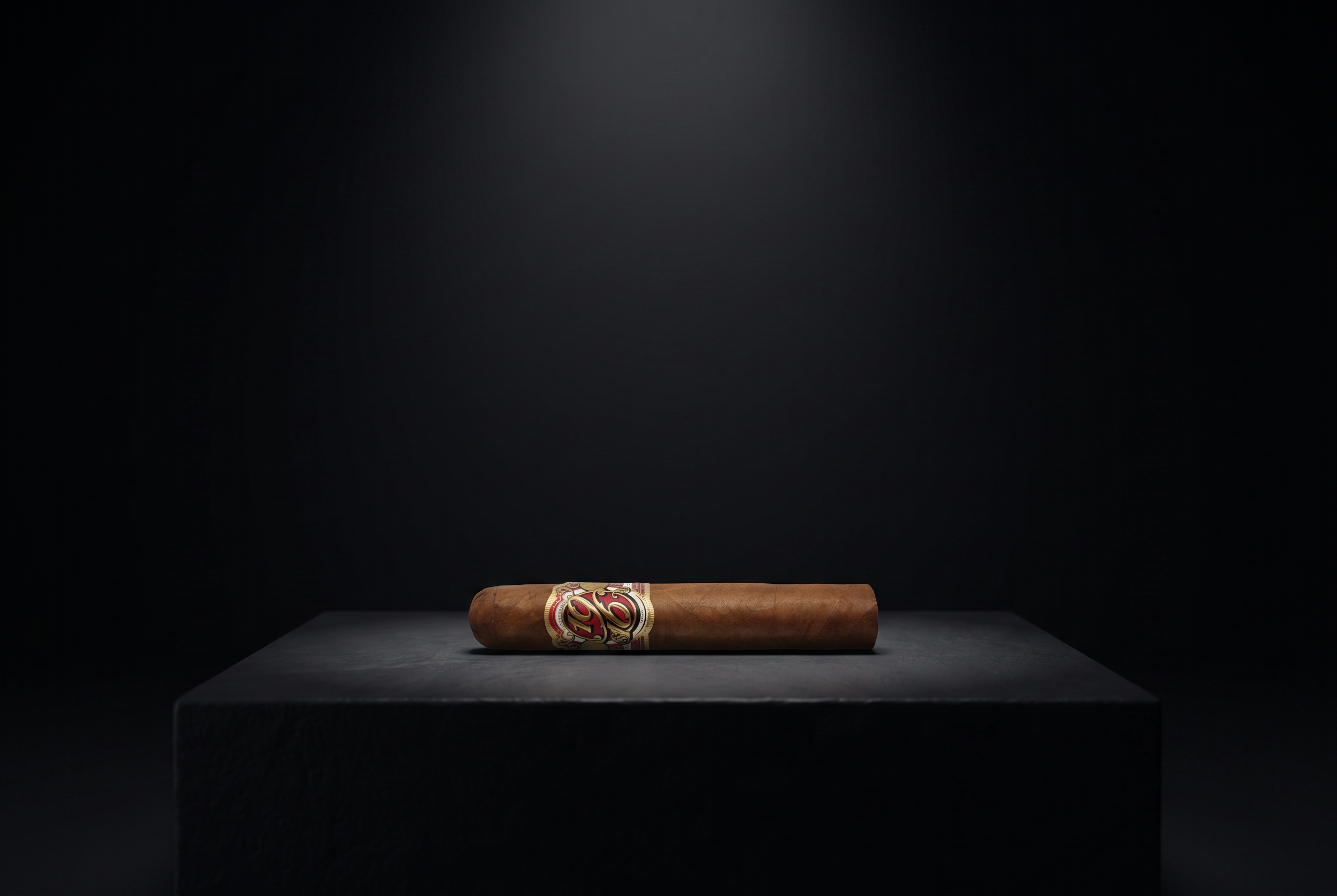 A single 1916 cigar displayed on a black plinth under gallery light